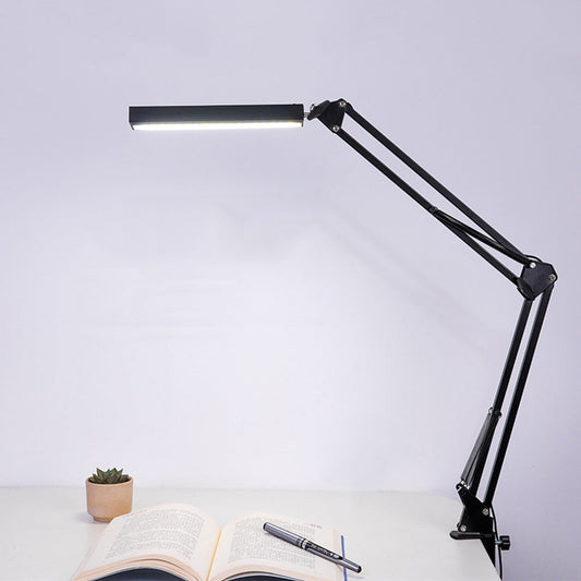 Vue de profil de la Lampe de Bureau ajustable, en utilisation accrochée à un bureau, sur un fond blanc - Disponible chez Kozyo